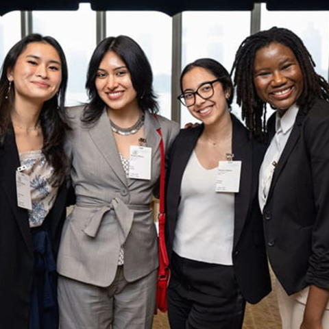 A group of four students stand together.