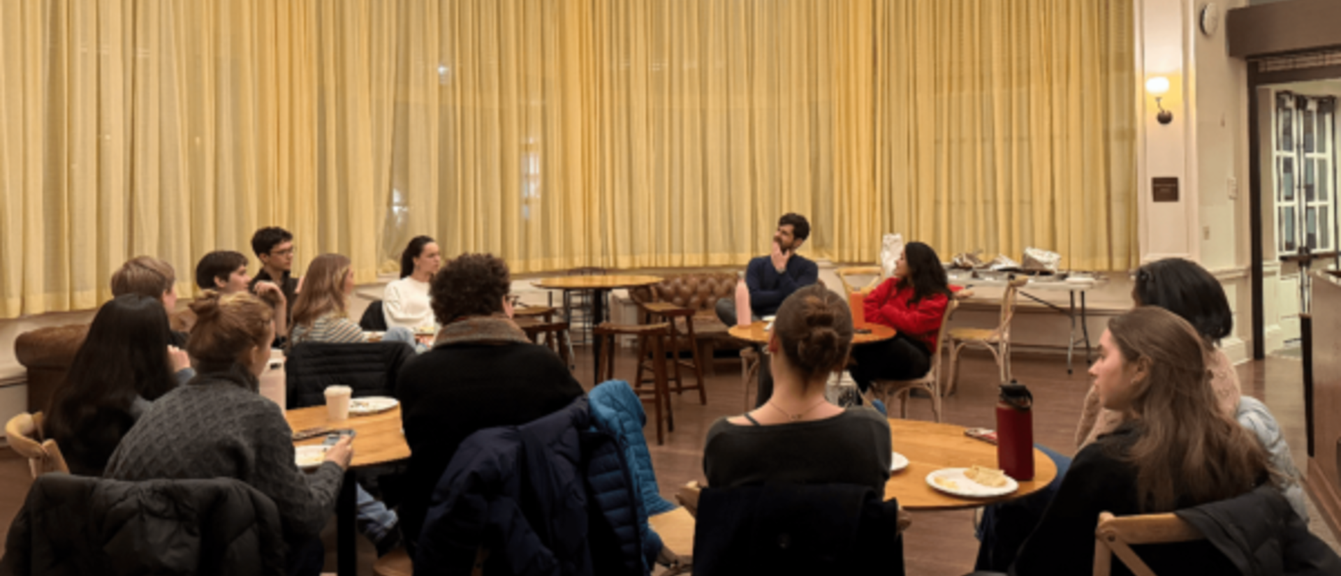 Two people speaking to a larger group of students