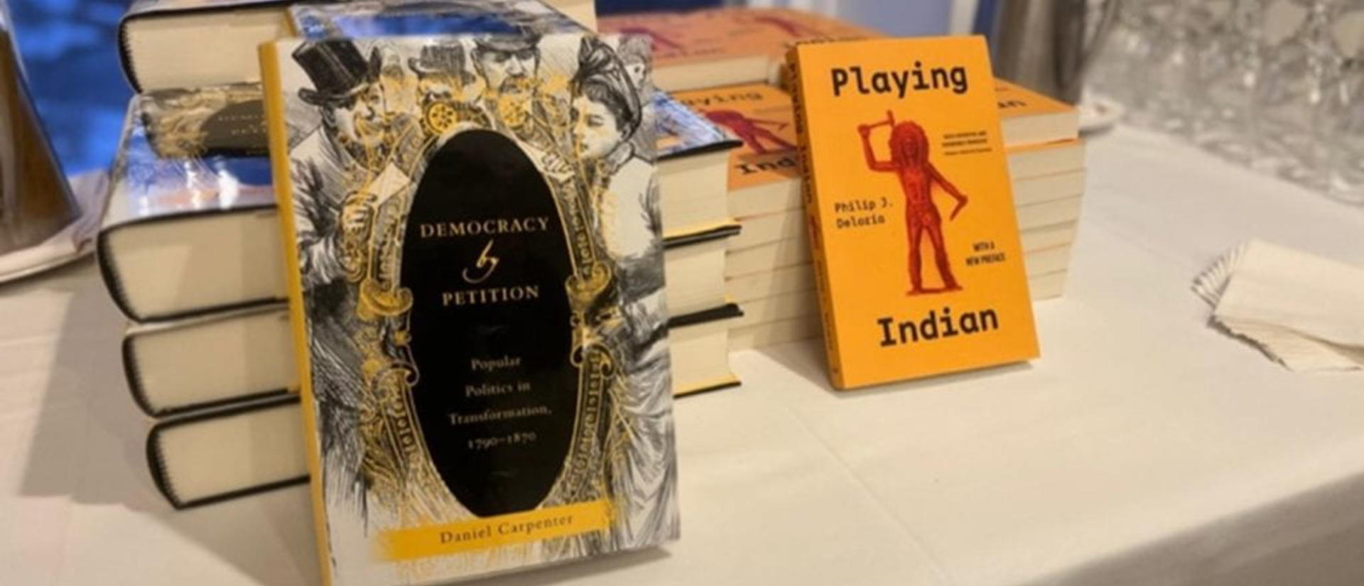 Two piles of books on a table.